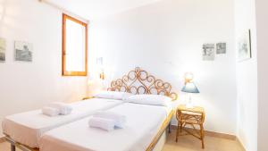 a bedroom with two beds with white sheets at Villa Brezza di Mare-Geremeas Country Club in Maracalagonis
