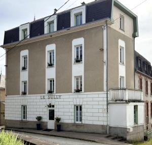 a large brick building with windows and a balcony at Le Sully in Mortroux