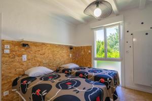 deux lits dans une chambre avec une fenêtre dans l'établissement Villa Cap mer 17, à Saint-Palais-sur-Mer 19 autres photos