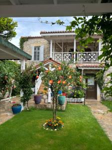 a house with a garden with a tree in the yard at Taşdelen Hotel in Alaçatı