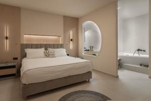 a bedroom with a large bed and a bath tub at Piccadill Luxury Villas in Methoni