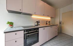a kitchen with white cabinets and a stove top oven at 3 Bedroom Nice Apartment In Oostende in Ostend