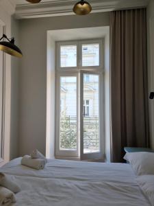 a bedroom with a white bed with a window at Apartamenty Inspiracja in Kraków
