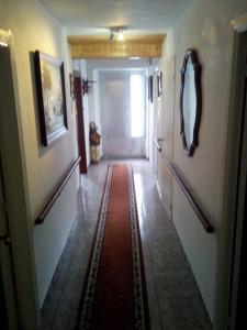 korytarz z czerwonym dywanem na podłodze w obiekcie Camino Bed and Breakfast Corme w mieście Corme-Puerto