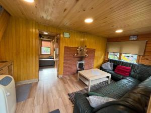 a living room with a couch and a fireplace at Cozy Forest Cabin in Kadaga