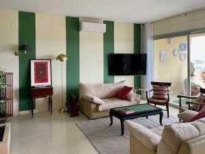 a living room with two couches and a tv at Nid d'Aigle - Parking et vue exceptionnelle sur Carcassonne in Carcassonne