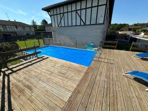 a swimming pool on a wooden deck at Charmante maison comme chez soi in Saint-Amand-sur-Fion
