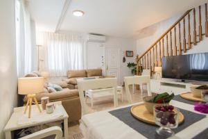 ein Wohnzimmer mit Sofa und Fernseher in der Unterkunft Villa Albufera Beach Retreat in Sueca