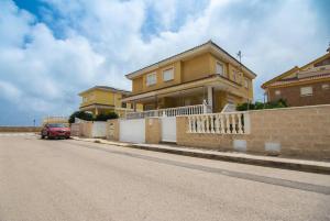 ein Auto, das vor einem Haus in einer Straße geparkt ist in der Unterkunft Villa Albufera Beach Retreat in Sueca