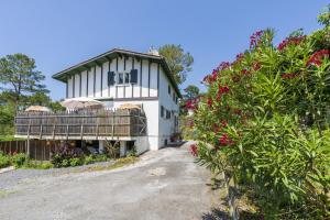 Casa blanca con balcón y algunas flores en Vacances Pays Basque, en Bidart