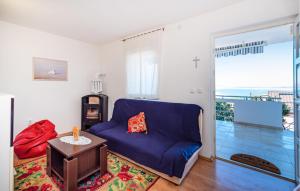a living room with a blue couch and a table at Stunning Home In Rovanjska With Wifi in Rovanjska