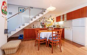 a kitchen with a table and chairs and a staircase at Stunning Home In Rovanjska With Wifi in Rovanjska