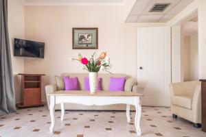 a living room with a couch and a table with flowers on it at Tresor Sousouras in Hanioti