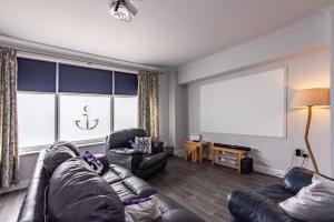 a living room with a couch and chairs and a large window at Maritime House Two - 4BR Sleeps 10 Near City Centre in Hull +28 photos