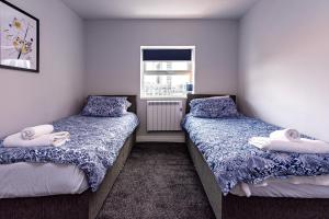 a bedroom with two beds and a window at Maritime House Two - 4BR Sleeps 10 Near City Centre in Hull