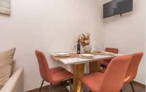 una sala da pranzo con un tavolo con sedie e una tv di Nice Apartment In Biograd Na Moru a Biograd na Moru