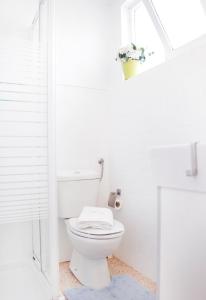 a white bathroom with a toilet and a sink at Sintra Sol - Apartamentos Turisticos in Sintra