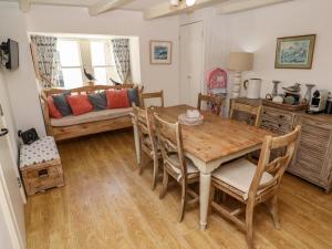 a dining room with a table and chairs and a couch at Cormorant Cottage in St Ives