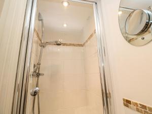 a bathroom with a shower with a mirror at Cormorant Cottage in St Ives +31 photos