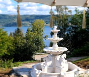 a white fountain with a view of a lake at VILLA HASSELBAKKEN in Eidsvoll
