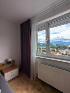 a bedroom with a large window with a view at Penthouse near Red Bull Ring in Knittelfeld +5 photos