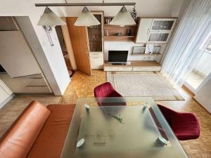 a living room with a glass table and red chairs at Penthouse near Red Bull Ring in Knittelfeld