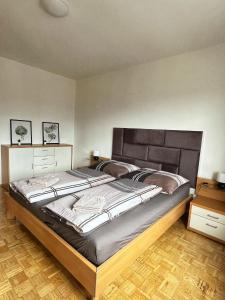 a bedroom with a large bed and a wooden floor at Penthouse near Red Bull Ring in Knittelfeld