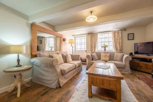 a living room with a couch and a tv at Skeet Cottage in Burnham Market
