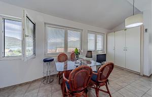 a dining room with a table and chairs and windows at 2 Bedroom Gorgeous Home In Hodilje in Hodilje