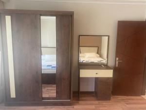 a small room with a bed and a mirror at Amazing apartment compound in Cairo