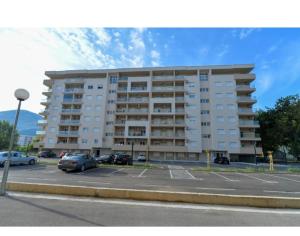 un gran edificio de apartamentos con coches aparcados en un aparcamiento en Apartman Darija 4, en Trebinje