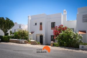a white building with flowers in front of it at #232 Vila Girasol 33 by Home Holidays in Albufeira