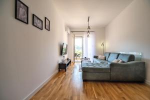 Una sala de estar con un sofá y un televisor. en Apartman Darija 4, en Trebinje