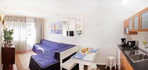 sala de estar con sofá azul y mesa en Sintra Sol - Apartamentos Turisticos, en Sintra