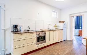 a large kitchen with white walls and wooden floors at Lovely Apartment In Fazana With Wifi in Fažana