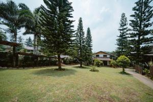 a large yard with trees and a house at Pina Colina Resort Tagaytay City by RedDoorz in Tagaytay