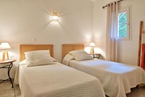 two beds sitting next to each other in a room at Villas Abbartello in Olmeto +39 photos
