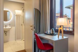 ein Hotelzimmer mit einem Schreibtisch und einem roten Stuhl in der Unterkunft HOTEL DELLE CIVETTE in Rom