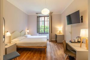 ein Schlafzimmer mit einem Bett, einem Schreibtisch und einem Fernseher in der Unterkunft HOTEL DELLE CIVETTE in Rom