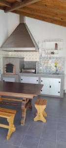 a kitchen with a wooden table and a stove at Casa do Castelo in Gafanha da Nazaré