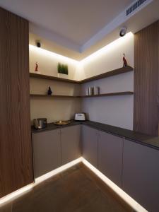 a kitchen with white cabinets and a counter with lights at NAP Luxury Guest House Municipio in Naples