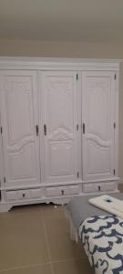 a white cabinet with four doors in a room at Casa do Castelo in Gafanha da Nazaré