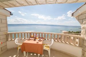 a table and chairs on a balcony with a view of the ocean at Villa Nada - room for 2 in Duće