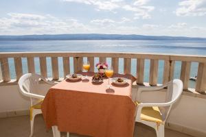a table with two glasses of wine on a balcony at Villa Nada - room for 2 in Duće