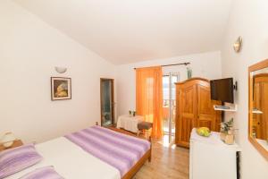 a bedroom with a bed and a television in it at Villa Nada - room for 2 in Duće