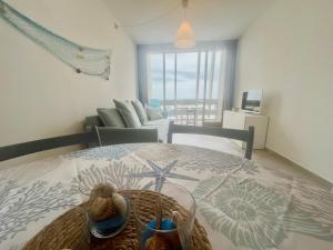 a bedroom with a bed with a basket and a living room at Appartamento Zipser II in Grado