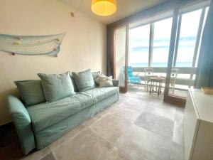 a living room with a green couch and a table at Appartamento Zipser II in Grado