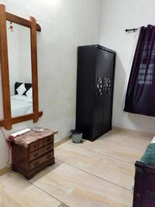 a room with a mirror and a dresser and a mirror at Green Island Homestay Riverside in Kozhikode