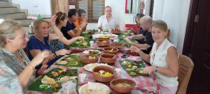 a group of people sitting at a table eating food at Green Island Homestay Riverside in Kozhikode +47 photos