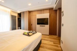 a bedroom with a large bed and a flat screen tv at NAP Luxury Guest House Municipio in Naples